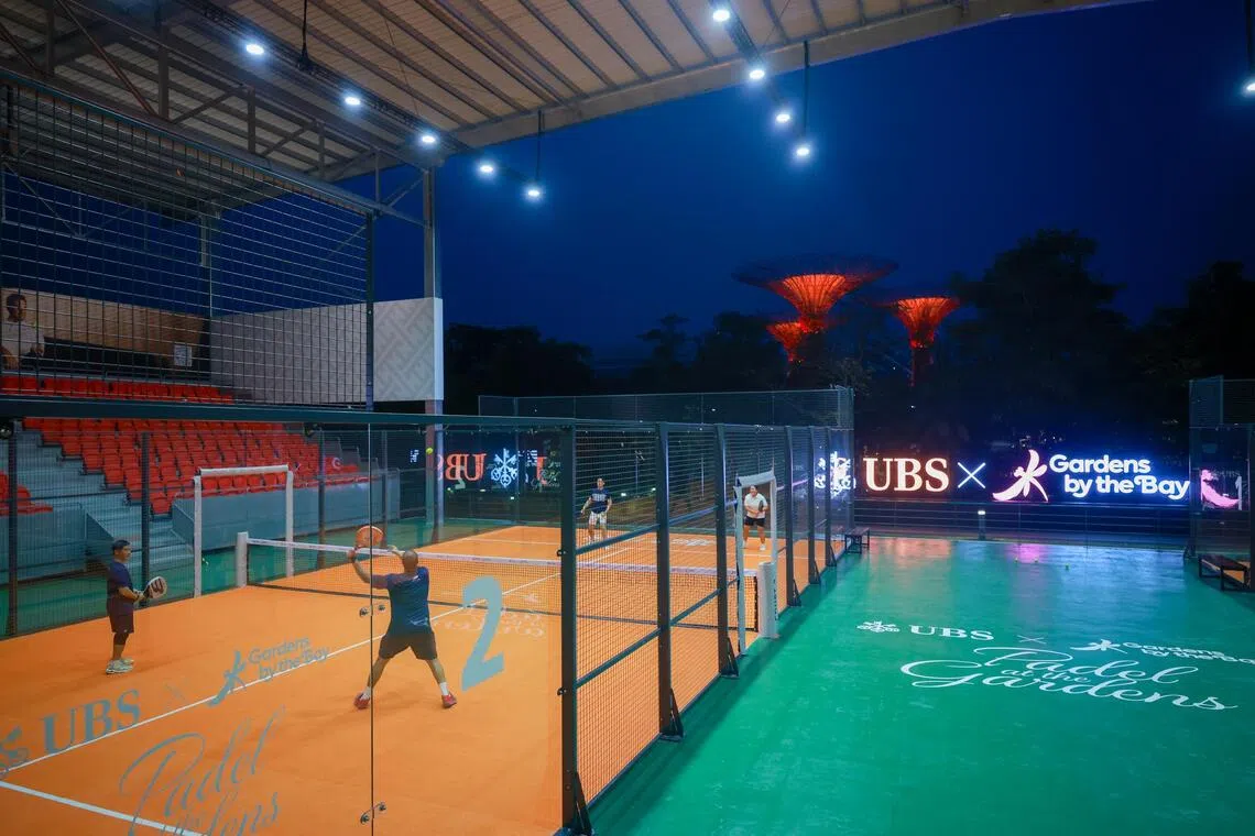 People playing padel at Gardens by the Bay with the Supertrees in the background